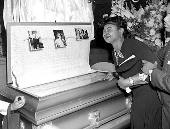 Emment Till's mother (Mamie Till) by his open casket 